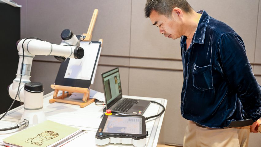 嘉賓體驗(yàn)遨博AI繪畫機(jī)器人。主辦方供圖